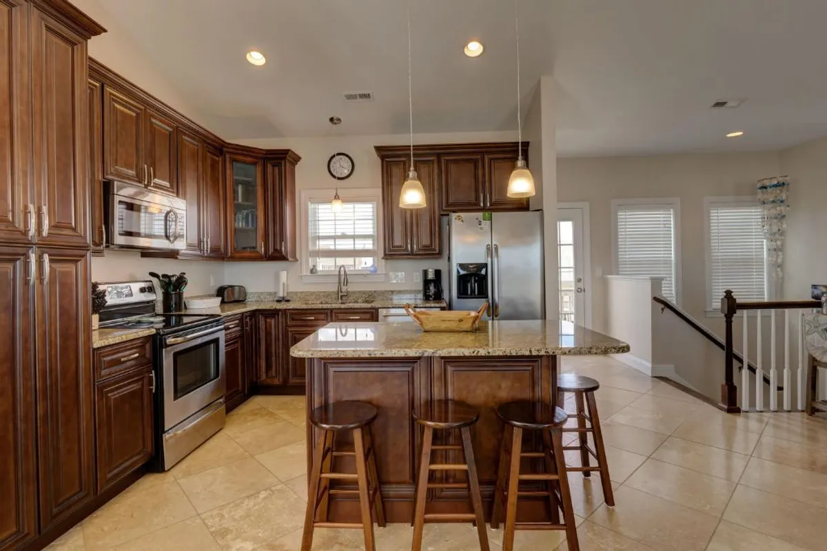 The modern kitchen area is highlighted here, with a spacious kitchen island, stainless steel appliances, and ample cabinetry. The open layout is perfect for preparing meals and socializing.